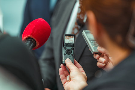 A businessman is interviewed at a trade show, sharing his insights and knowledge on new trends and developments.の写真素材