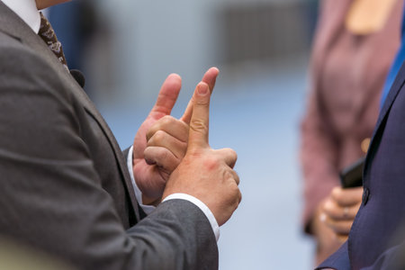 A businessman uses his hands to explain complex concepts to a group of attendees at a trade show....