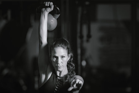 Female Athlete Exercising with Kettlebell.