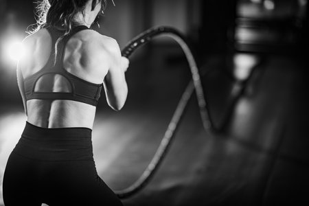 Agility training, woman exercising with rope in a gym.の写真素材
