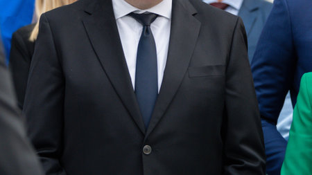 Close-up shot of a suited man at a technology trade show, showcasing the essence of elegance and tech expertiseの写真素材