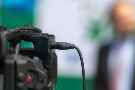 Close-up shot captures a TV camera recording a press conference, delivering impactful media coverage...