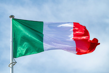 The national flag of Italy waving in the blue skyの写真素材