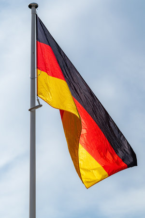 The national flag of Germany waving in the blue skyの写真素材