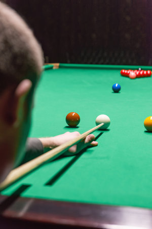 A focused snooker player demonstrating skill and precision during a competitive gameの写真素材