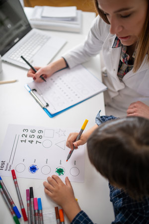 Early cognitive development as toddler engage in a psychology test through coloring various shapes,...