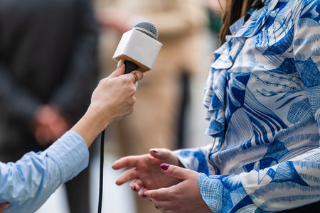 A journalist conducts an interview, capturing reactions and insights during the opening ceremonyの写真素材