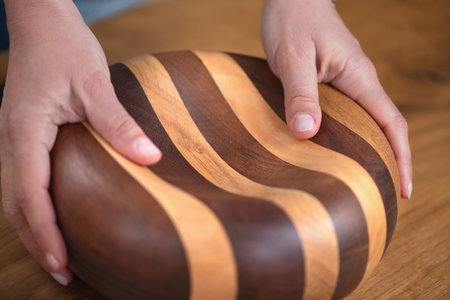Female hand showcases an elegant, crafted and unique wooden item.の写真素材