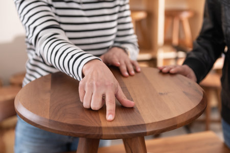 Interior decorator choosing furniture, holding a wooden chairの写真素材
