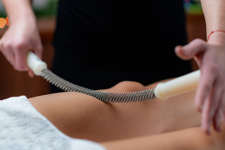 Massage therapist targets cellulite with precision using a metal rolling pin in this groundbreaking anti-cellulite treatmentの写真素材