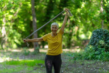 Senior woman exercising with resistance band for effective exercise in the park.