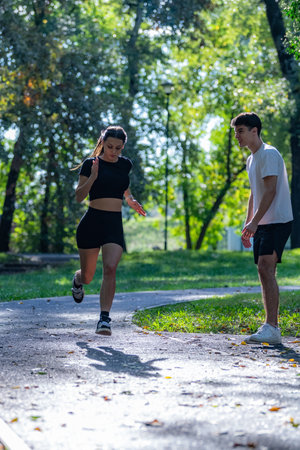 Couple running in a park, embracing an active lifestyle and fitness routine. The image highlights health, energy, and the joy of exercising together in a natural, serene environment.の写真素材