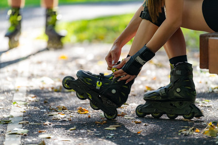 Couple prepares for an outdoor rollerblading adventure, putting on their rollerblades together in a...