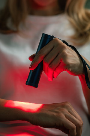 Red light therapy on the wrist reduces pain and inflammation from strain or arthritis. It boosts blood flow and aids tissue healing, enhancing movement and comfort with non-invasive treatment.の写真素材