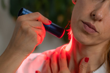 Woman receiving red light therapy on the neck, a treatment known for improving skin elasticity, reducing wrinkles, and relieving muscle tension using LED light technology.の写真素材