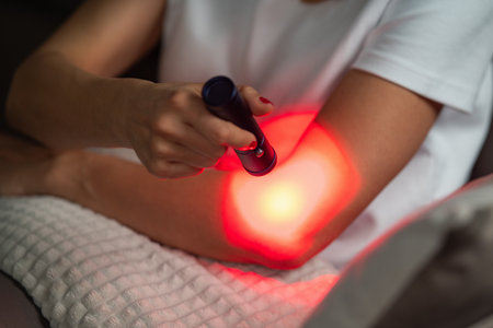 Red light therapy on the elbow reduces inflammation and pain from strains or arthritis. It improves circulation and tissue repair, enhancing joint mobility and comfort.の写真素材