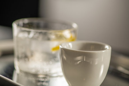 Cup with water glass on counter in coffee shop. Highlights aroma, crema, and serving culture of traditional cafe hospitality.の写真素材