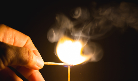 Fire match on dark blackgroundの写真素材