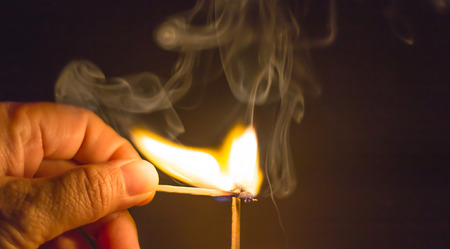 Fire match on dark blackgroundの写真素材