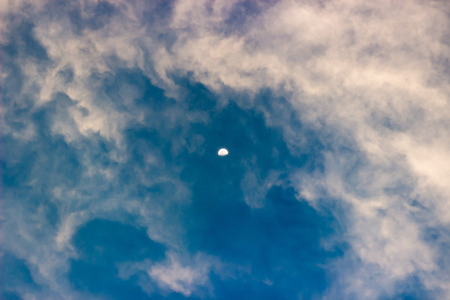 Cloud and moon on blue sky