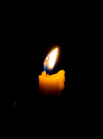 Light of candle burning in the dark. Black backgroundの写真素材
