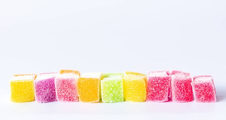 Close up a row of colorful jelly with sugar on whiteの写真素材