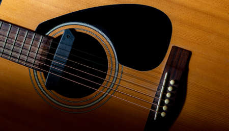 Close up detail of orange acoustic guitar