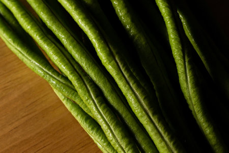 Close up green yardlong bean on wood cutting board