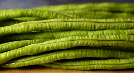 Close up green yardlong bean on wood cutting boardの写真素材