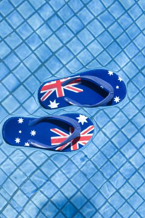 Pair of sandals printed with the Australian flag floating on a pool.の写真素材