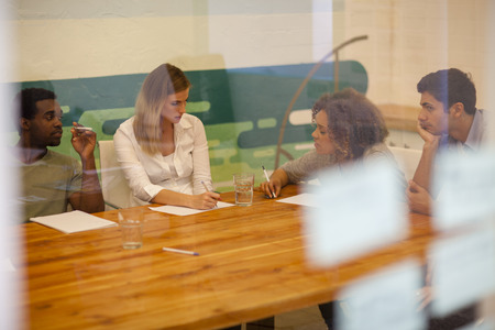 Team of entrepreneurs in discussion within their startup office boardroom