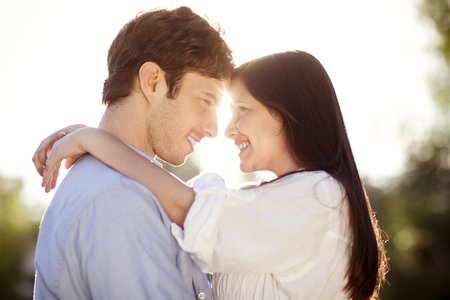 Young couple hugging outdoors in the sunの写真素材