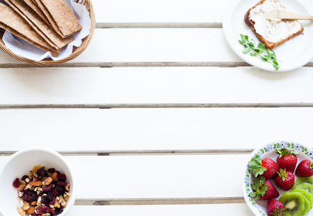 Table set for a typical breakfast with almonds, toast, crackers and fresh fruitsの写真素材