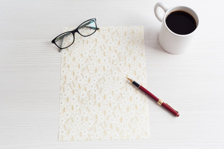 Top view business office. Coffee and decorative paper on white table.