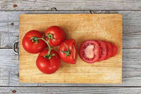 Close up of sliced tomato on wooden cutting boardの写真素材