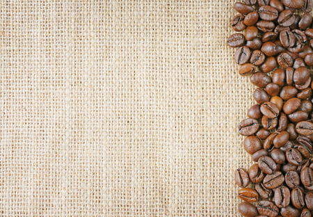 closeup top view coffee beans on juta backgroundの写真素材