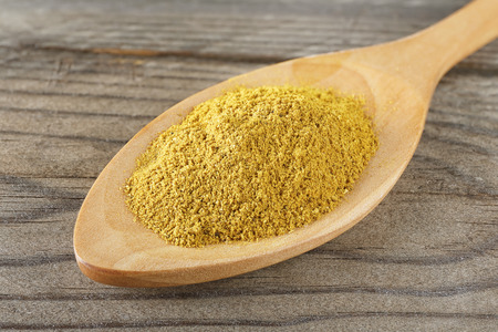 closeup macro wooden spoon with curry powderの写真素材