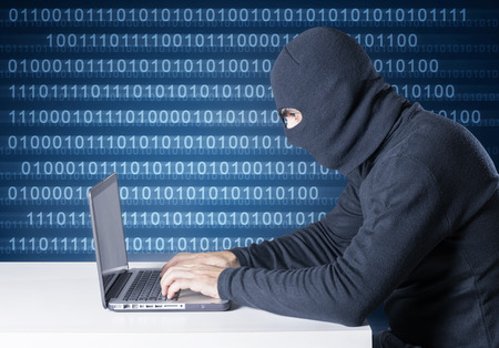hacker with laptop computer and background binary codeの写真素材
