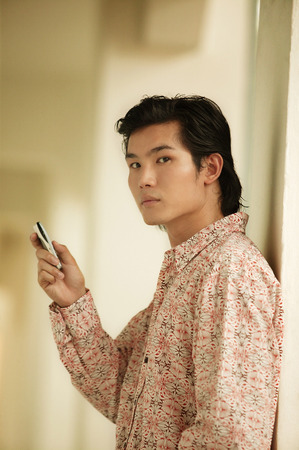 Young man holding mobile phoneの写真素材
