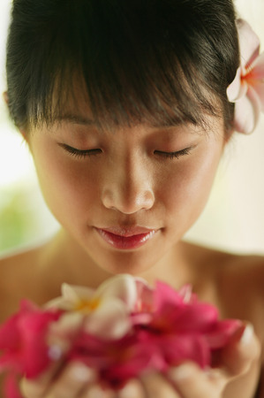 Portrait of a young woman, holding flowersの写真素材