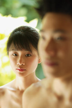 Young woman looking at camera, man in the foregroundの写真素材