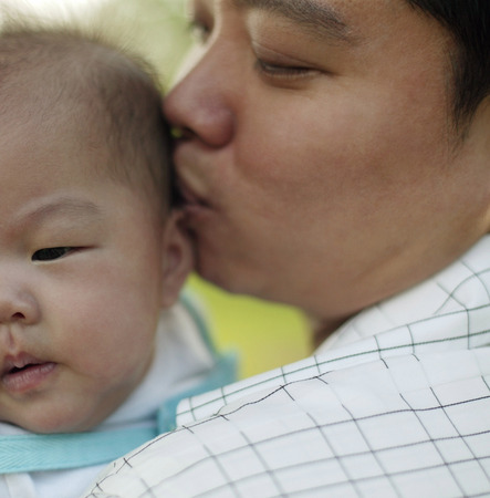 Father  kissing baby.の写真素材