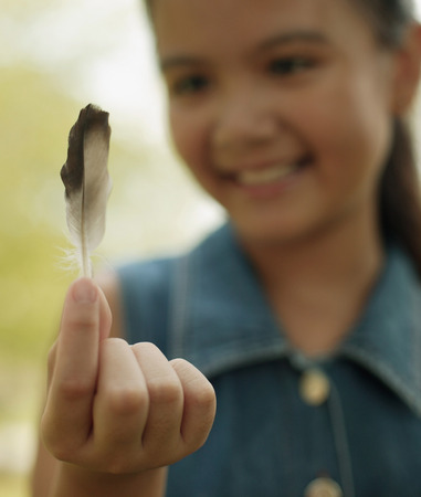 Young girl holding a featherの写真素材