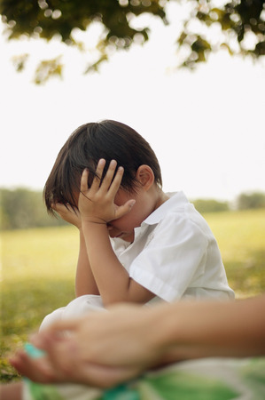 Young boy with hands on his faceの写真素材
