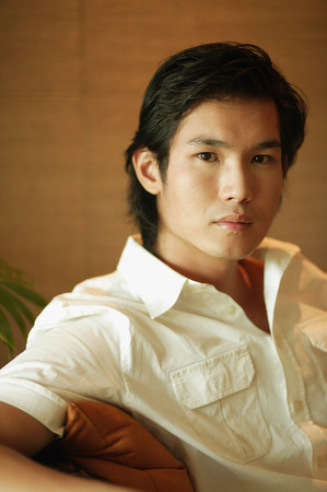 Young man sitting and looking at cameraの写真素材
