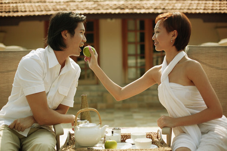 Young woman feeding young man.の写真素材