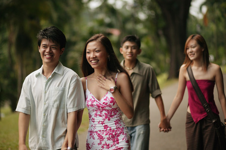 Couples walking hand in hand in parkの写真素材