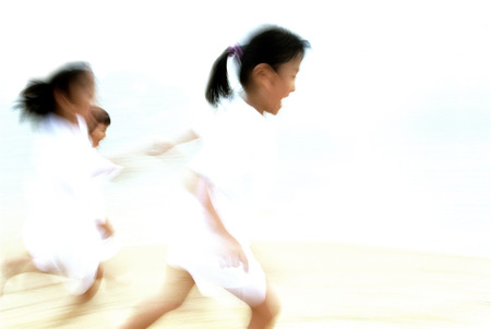Children in white clothing running (motion blur)の写真素材