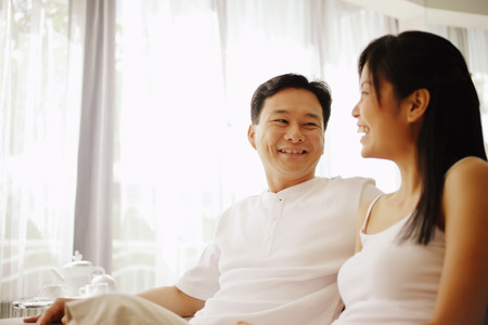 Couple sitting down side by side, talkingの写真素材