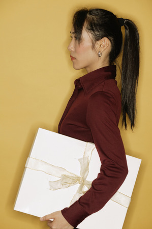 Young woman, side view, yellow backgroundの写真素材